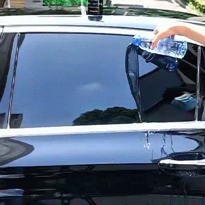 Hand applying spray on blue car hood
